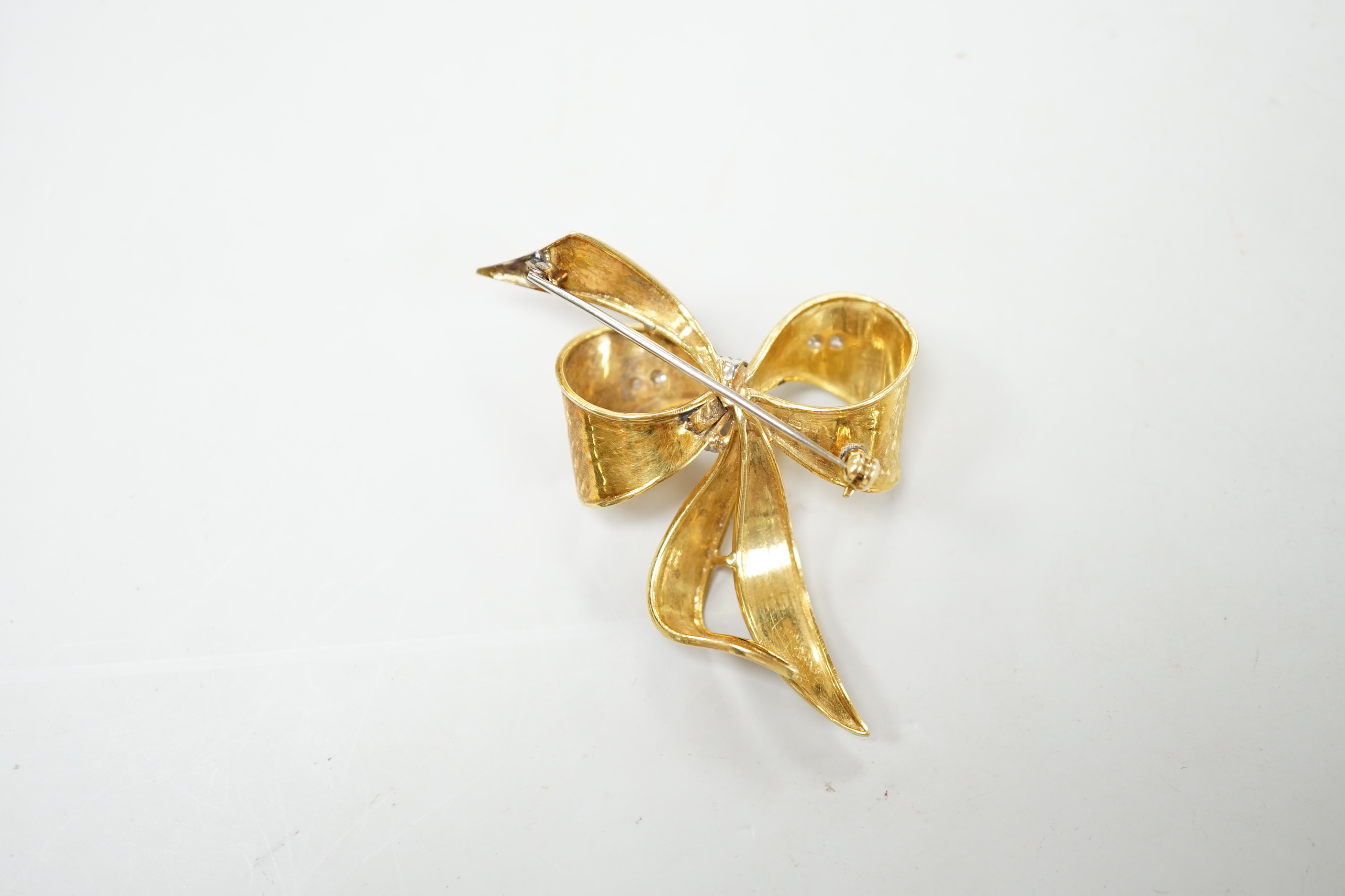 A 1970's 9ct gold and diamond chip set bow brooch, 51mm, gross weight 11.2 grams.